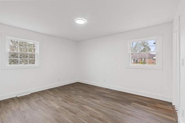 empty room featuring dark hardwood / wood-style floors and plenty of natural light