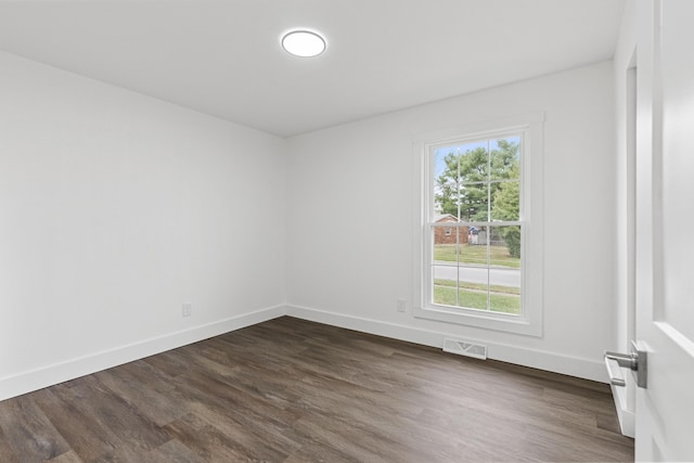 spare room with dark wood-type flooring and a wealth of natural light