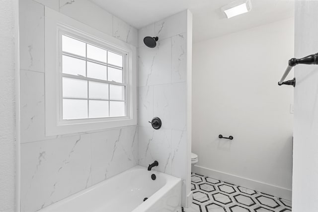 bathroom with tiled shower / bath combo and toilet