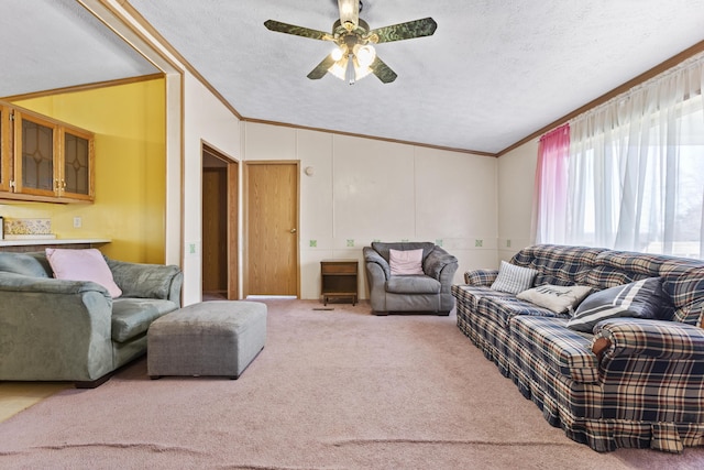 carpeted living room featuring vaulted ceiling, ceiling fan, a textured ceiling, and ornamental molding