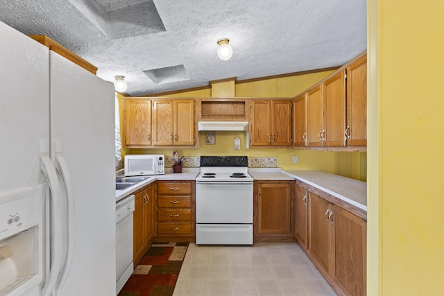 kitchen featuring vaulted ceiling, a textured ceiling, and white appliances