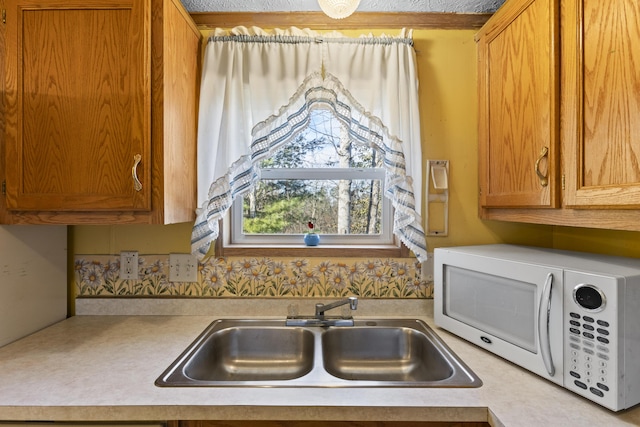 kitchen featuring a textured ceiling and sink