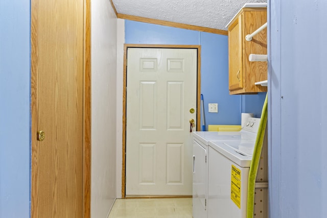 laundry area featuring cabinets, a textured ceiling, separate washer and dryer, and ornamental molding