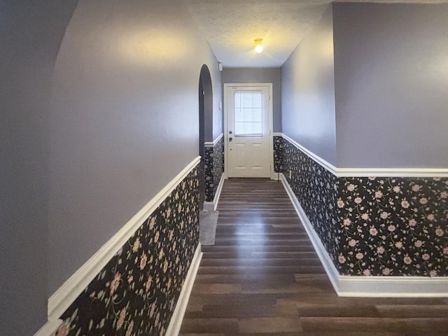 doorway featuring a textured ceiling and dark hardwood / wood-style floors