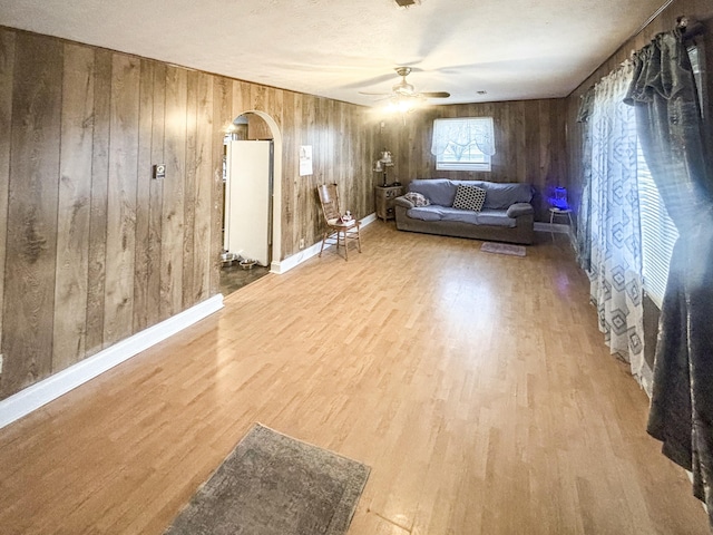 interior space featuring wood walls, hardwood / wood-style floors, and ceiling fan