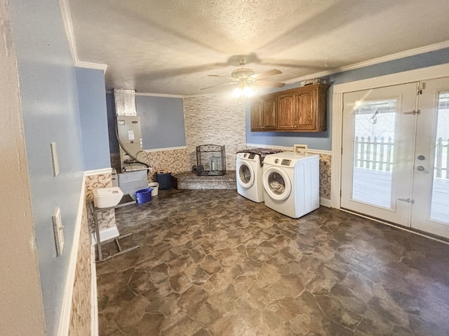 laundry area featuring ceiling fan, cabinets, crown molding, a textured ceiling, and washer and dryer