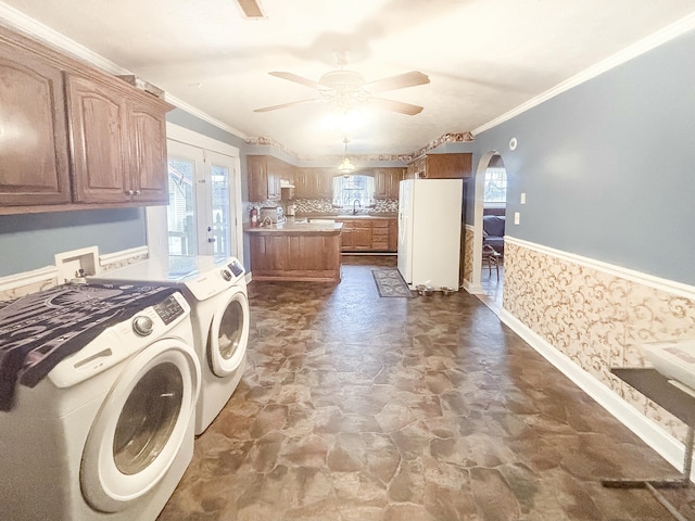 washroom with washing machine and clothes dryer, crown molding, sink, and ceiling fan