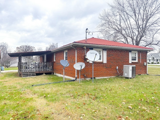 view of side of home featuring a lawn, a deck, and central AC