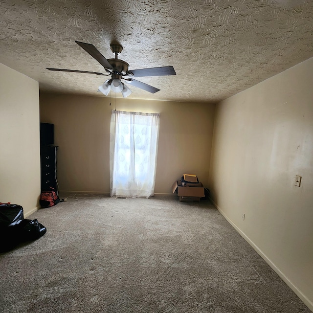 carpeted spare room with a textured ceiling and ceiling fan