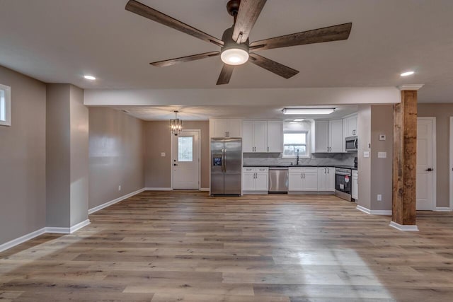 kitchen featuring ceiling fan with notable chandelier, light wood-type flooring, white cabinetry, and stainless steel appliances