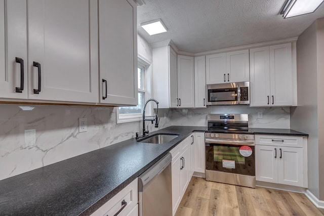 kitchen featuring backsplash, sink, white cabinets, and stainless steel appliances