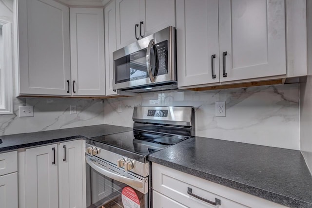 kitchen with backsplash, white cabinetry, and stainless steel appliances