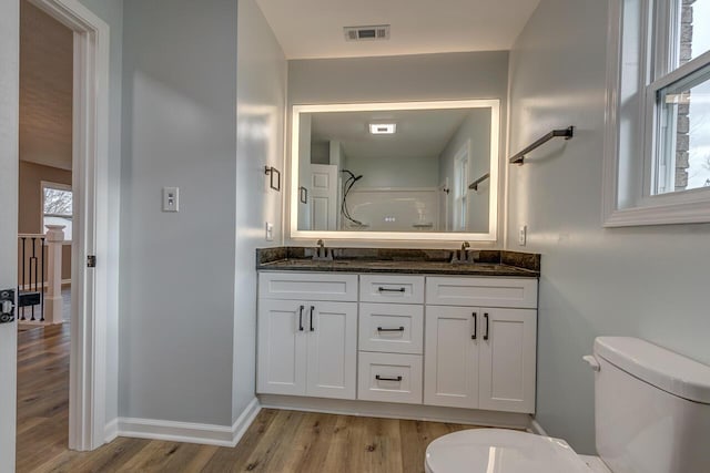 bathroom featuring walk in shower, toilet, vanity, and hardwood / wood-style flooring