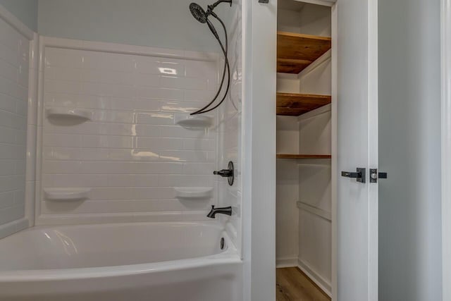 bathroom featuring hardwood / wood-style flooring and bathtub / shower combination