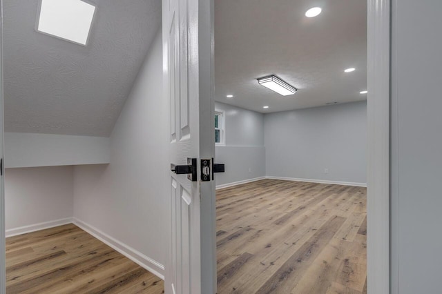 additional living space featuring light hardwood / wood-style flooring and lofted ceiling