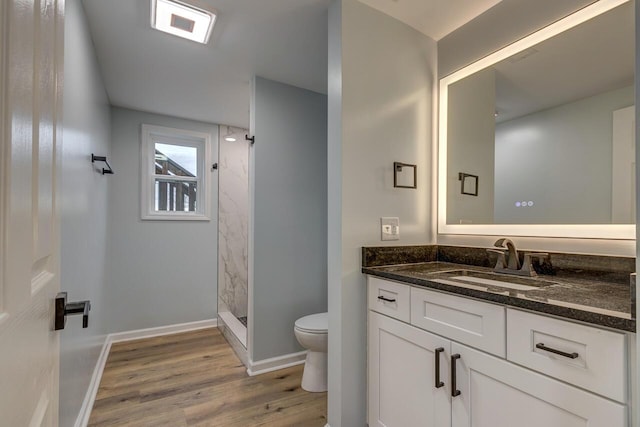 bathroom featuring toilet, hardwood / wood-style floors, vanity, and walk in shower