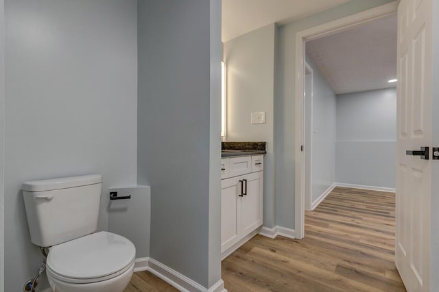 bathroom featuring toilet, vanity, and hardwood / wood-style flooring