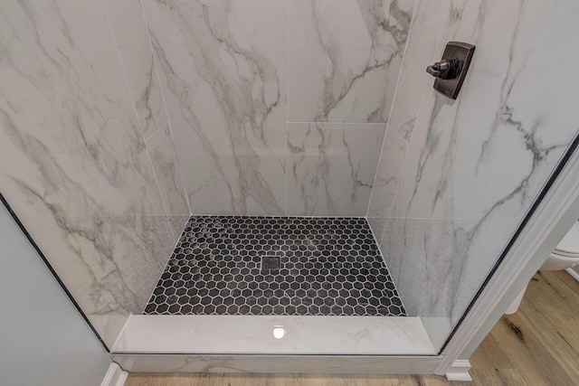 bathroom featuring tiled shower and hardwood / wood-style flooring