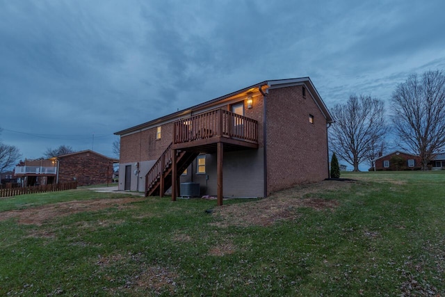 rear view of property with a wooden deck and a yard