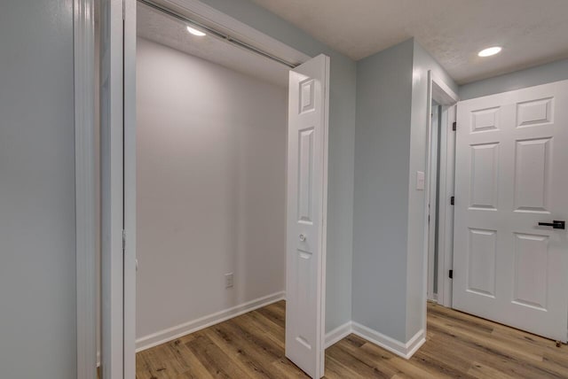 corridor featuring hardwood / wood-style floors and a textured ceiling