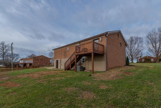 rear view of house with a lawn, a wooden deck, and central air condition unit