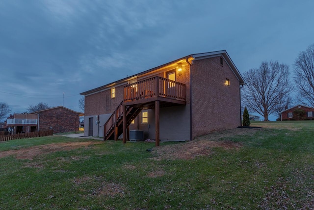 back of property with a yard, central air condition unit, and a wooden deck