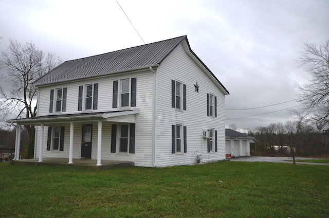 view of front of home with a wall mounted AC, a garage, a porch, and a front yard