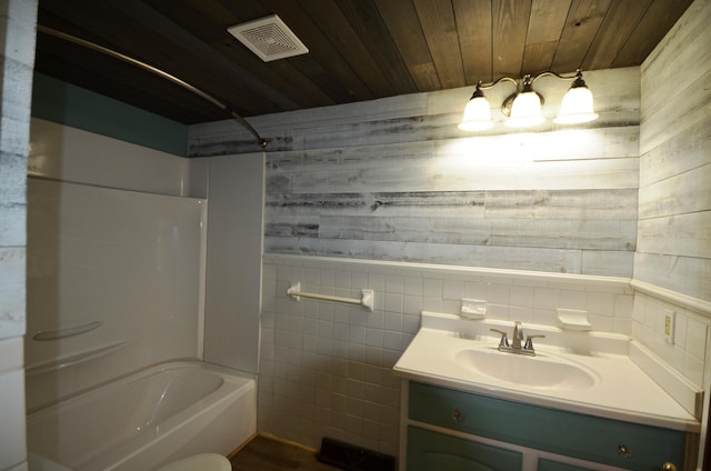 bathroom with vanity, wood walls, wooden ceiling, shower / tub combination, and tile walls