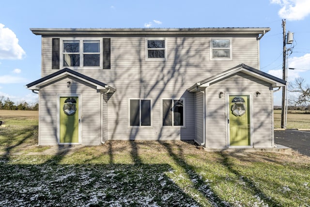 rear view of house featuring a yard