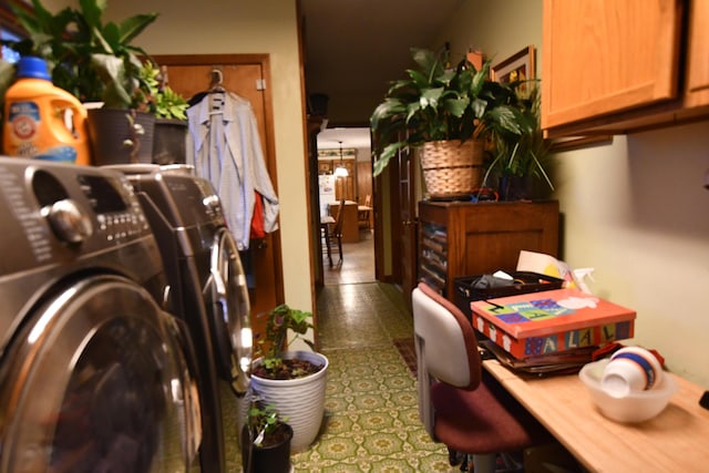 laundry area with washing machine and dryer, a notable chandelier, and cabinets