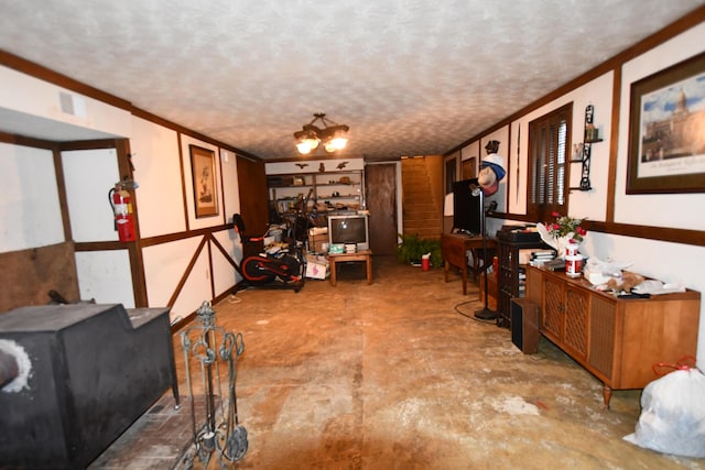 interior space with a textured ceiling, crown molding, a notable chandelier, and concrete flooring