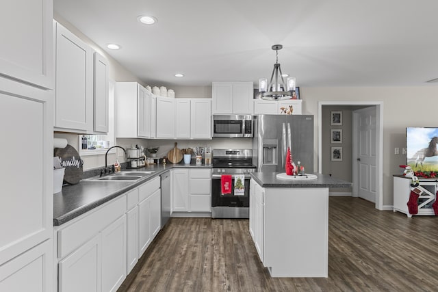 kitchen featuring dark hardwood / wood-style flooring, stainless steel appliances, sink, a center island, and white cabinetry