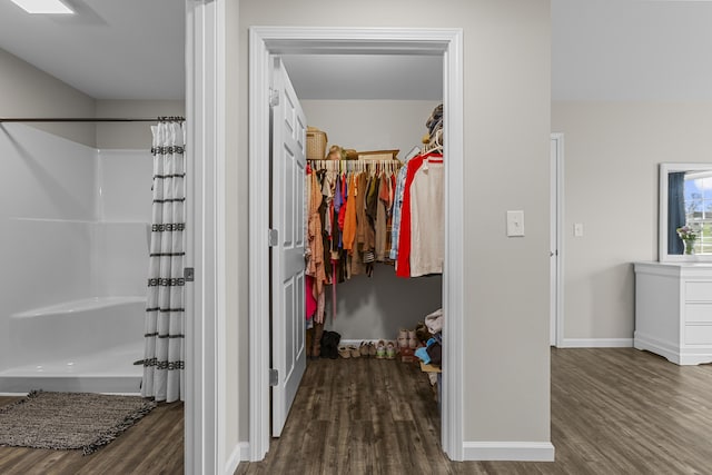 interior space featuring a shower with shower curtain and hardwood / wood-style flooring