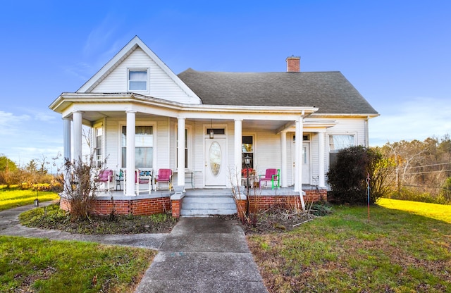 bungalow-style house with a front yard and covered porch