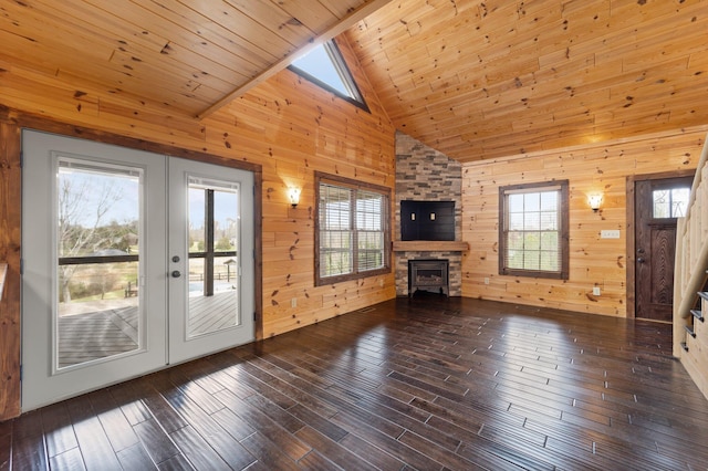 unfurnished living room featuring hardwood / wood-style flooring, a wealth of natural light, and wood walls