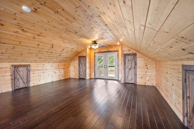 additional living space featuring lofted ceiling, dark hardwood / wood-style flooring, wood ceiling, and wooden walls