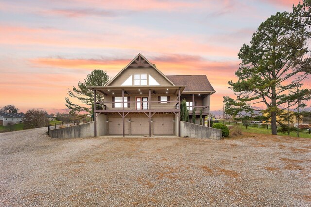 view of front of house featuring a balcony, a garage, and ceiling fan