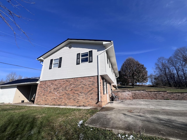 view of property exterior with a yard and a patio