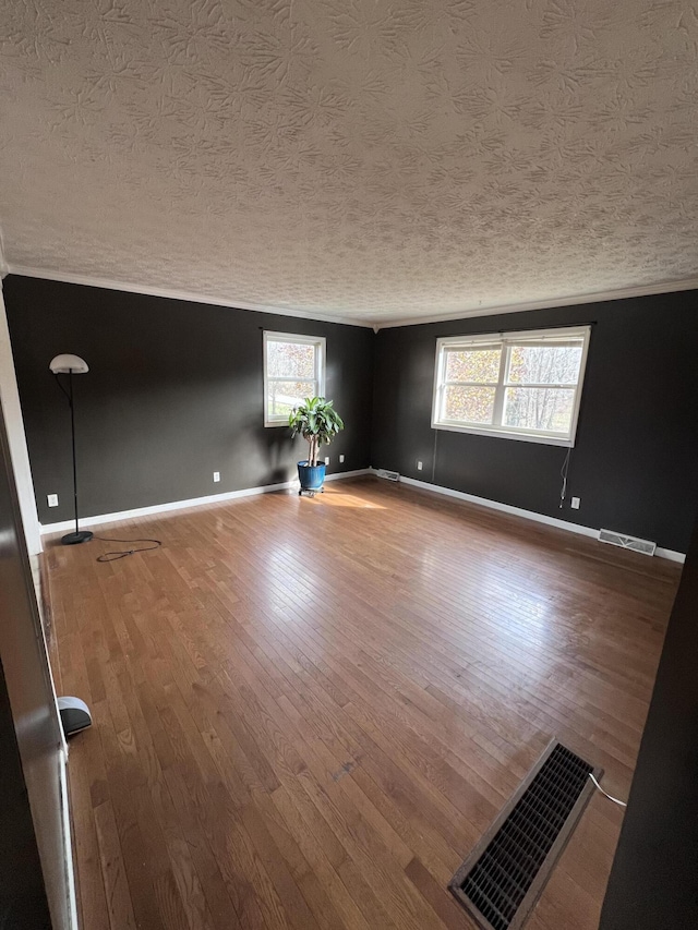 spare room with a textured ceiling and hardwood / wood-style flooring