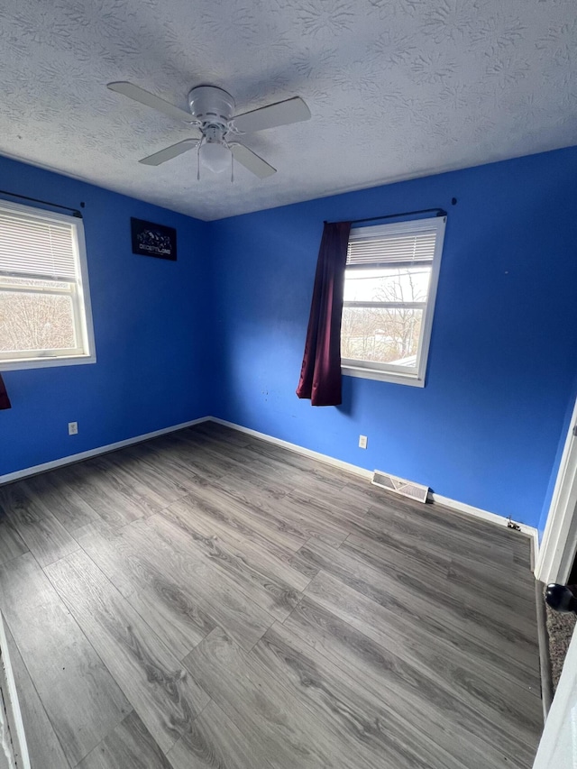 spare room featuring wood-type flooring, a textured ceiling, and ceiling fan