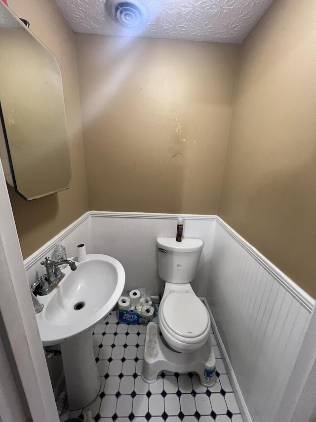 bathroom with a textured ceiling and toilet