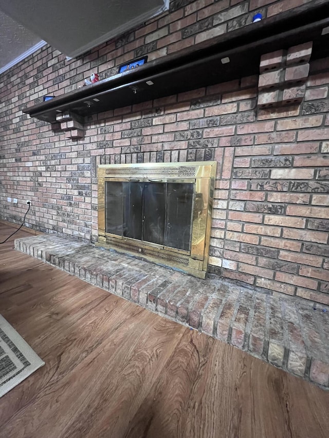 room details featuring hardwood / wood-style flooring and a brick fireplace