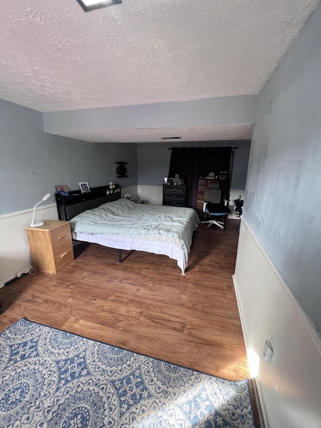 bedroom with hardwood / wood-style floors and a textured ceiling