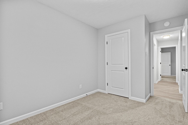 unfurnished bedroom with light carpet and a textured ceiling