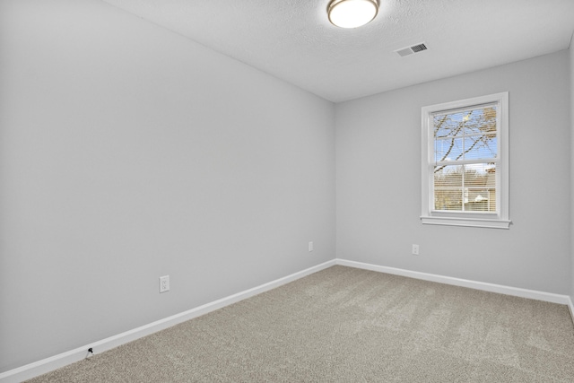 carpeted spare room featuring a textured ceiling