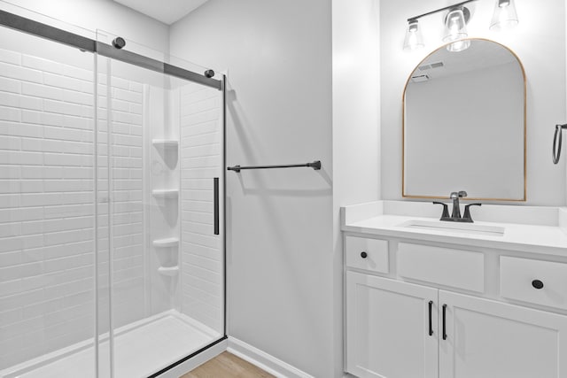 bathroom featuring vanity, a shower with shower door, and hardwood / wood-style flooring