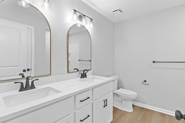 bathroom featuring vanity, toilet, and wood-type flooring