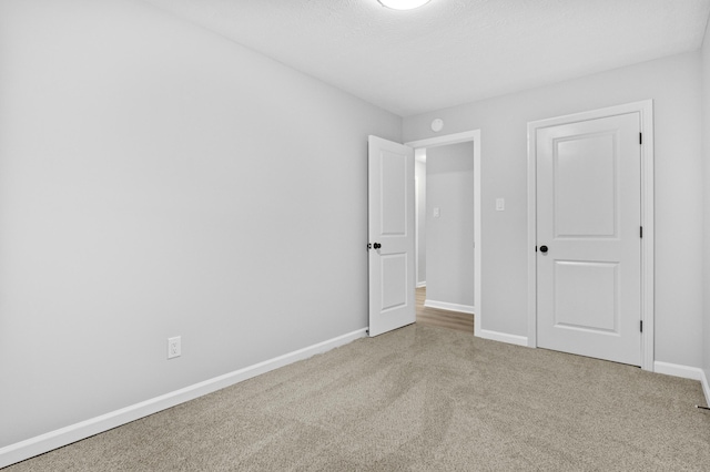 carpeted empty room featuring a textured ceiling