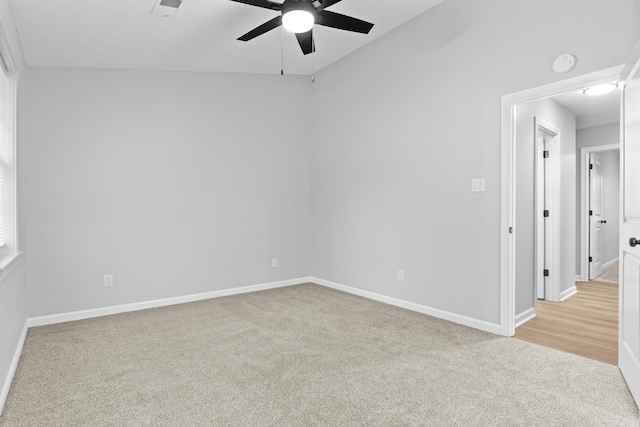 carpeted spare room featuring ceiling fan