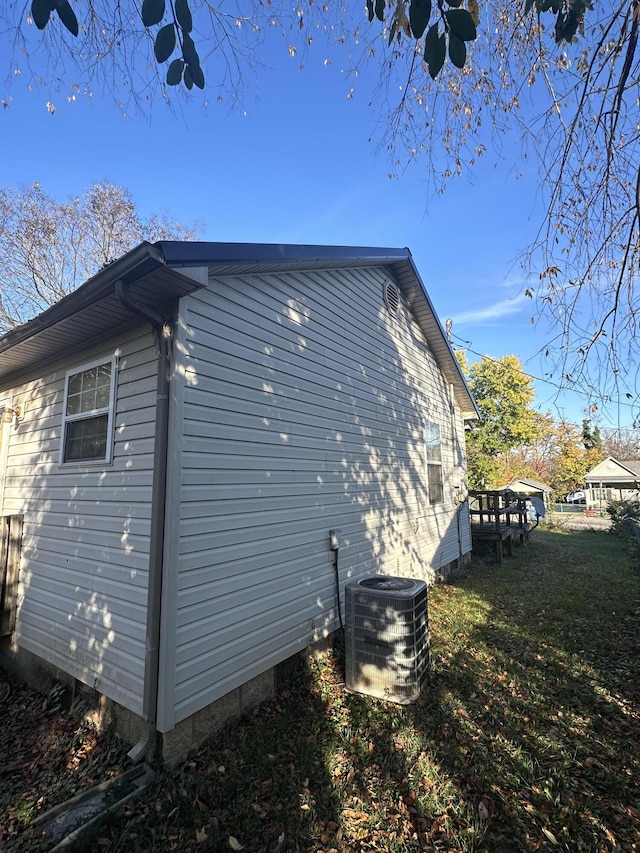 view of home's exterior featuring central AC unit and a lawn